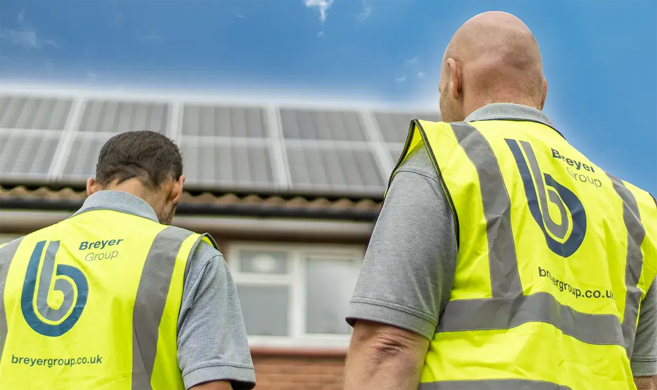 Two Breyer employees next to solar panel